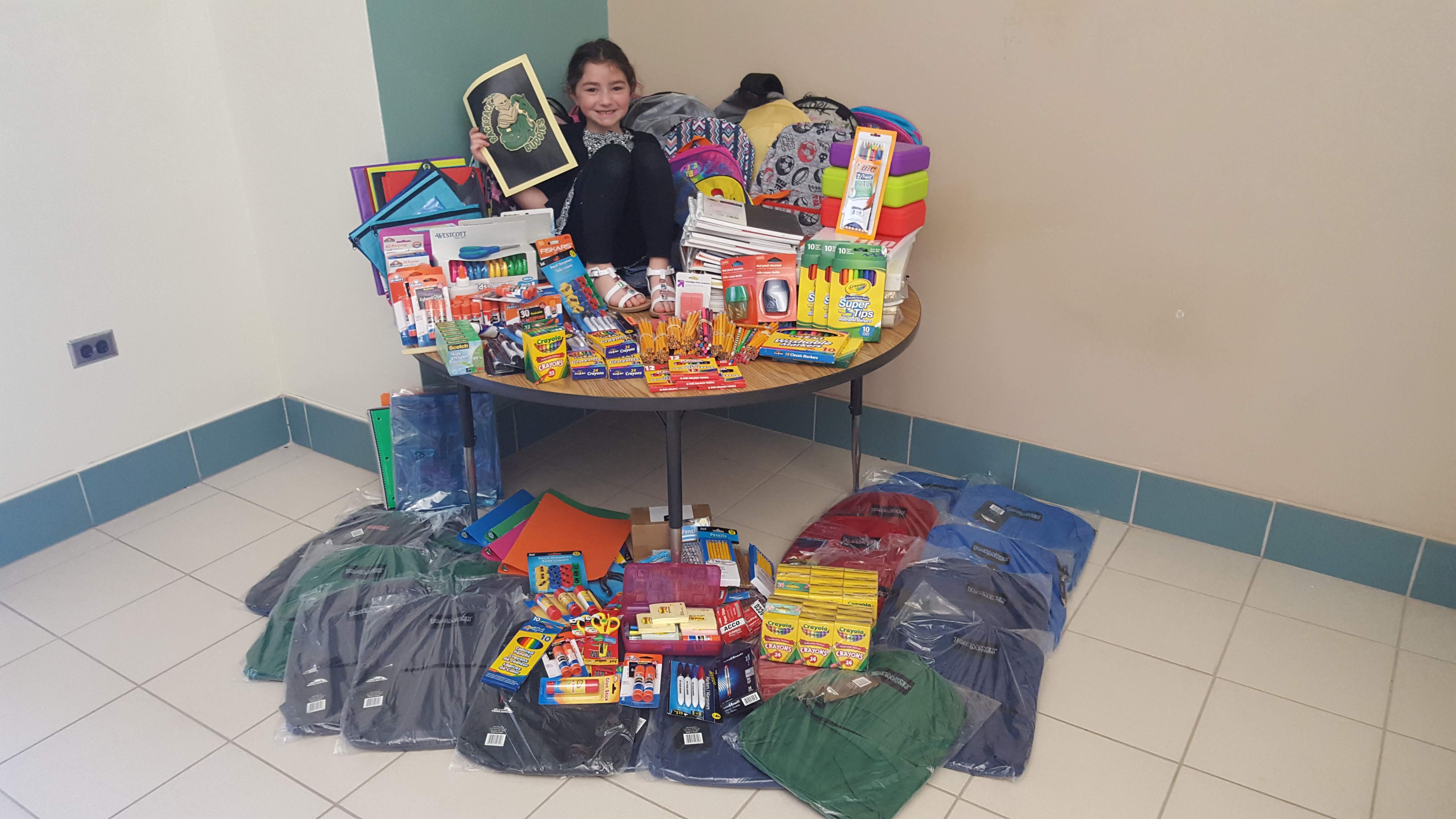 Rylee sits among donated supplies