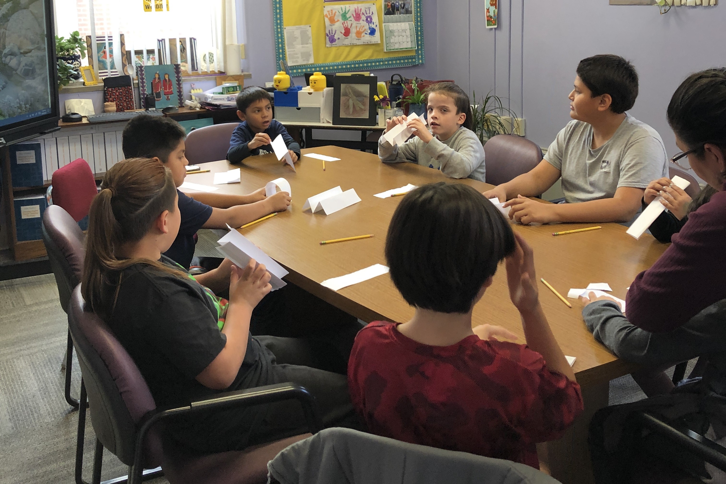 students gathered round table, working on crafts