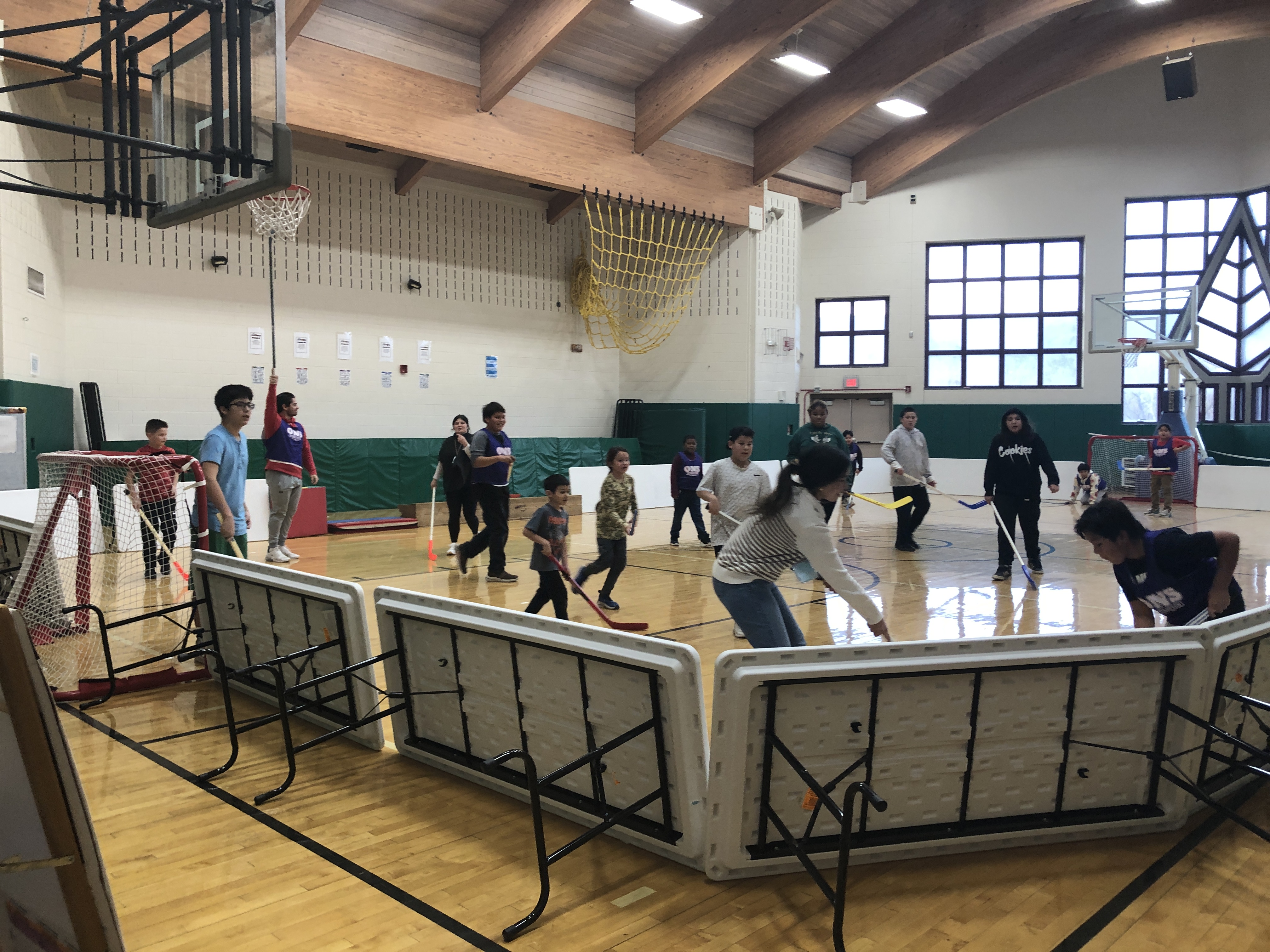 students playing hockey in gymnasium