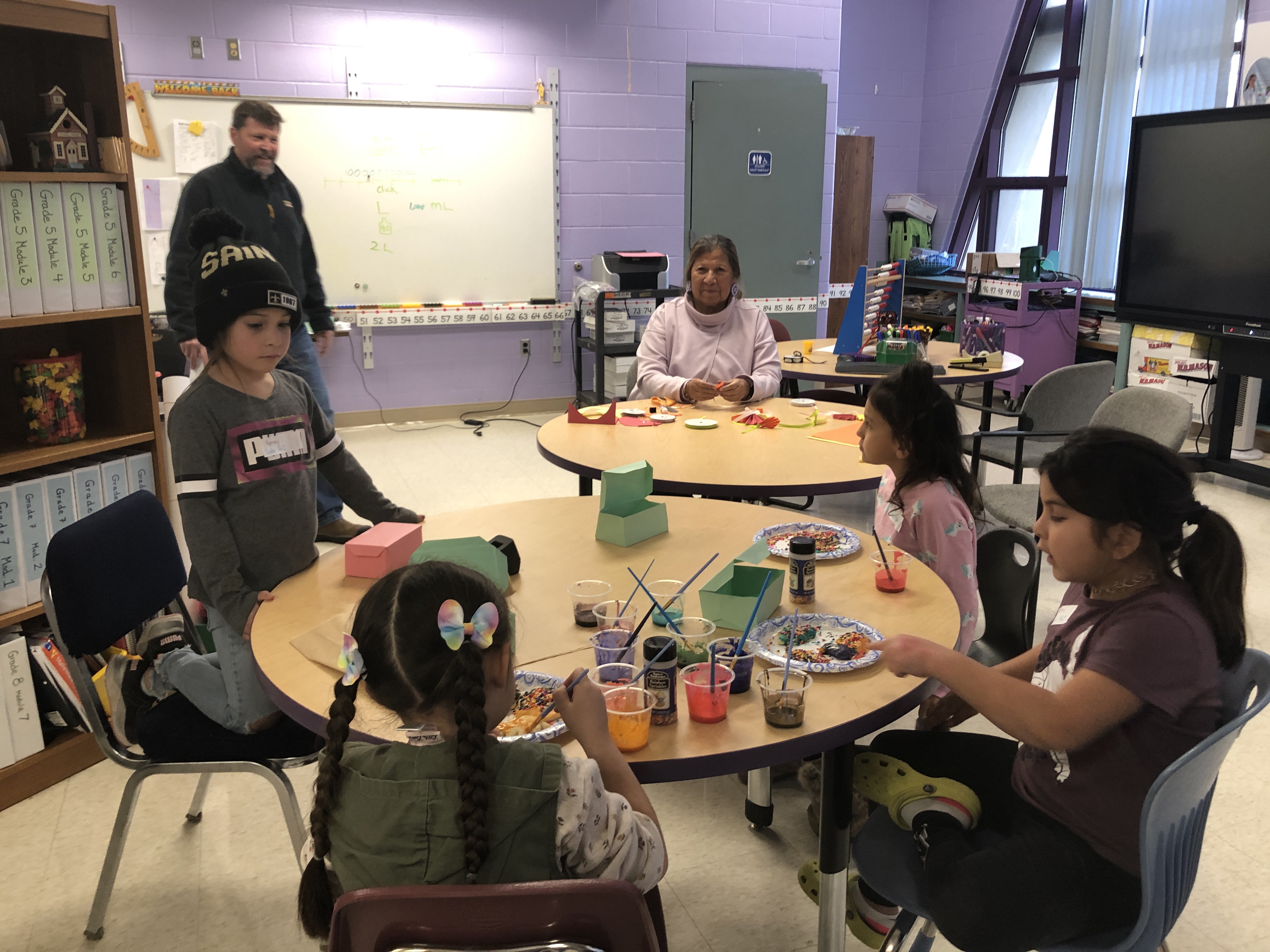 students using paint and glitter to create crafts