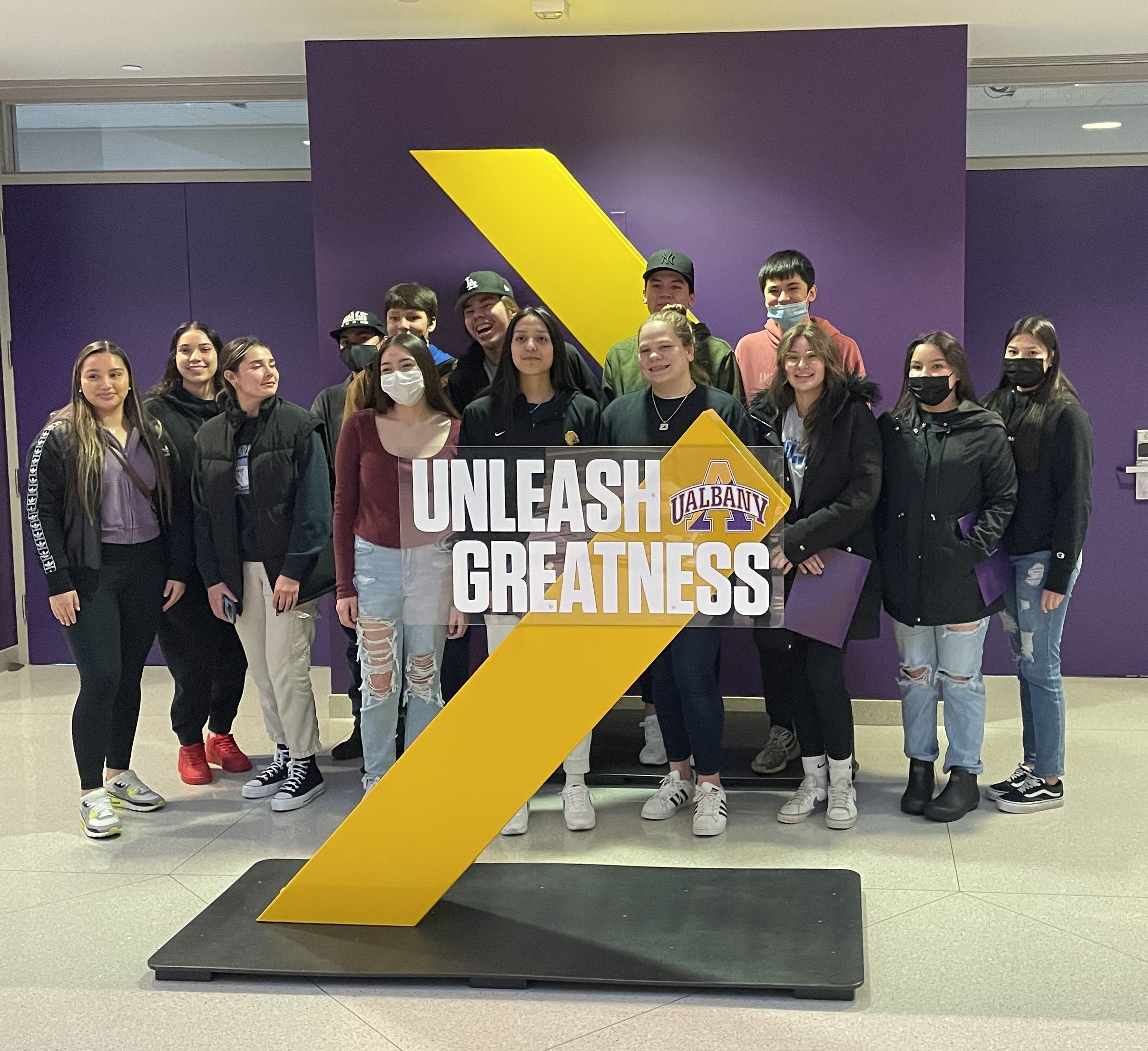 students take a group photo outside of university at albany